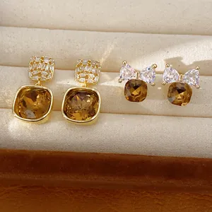 Detail van 14 karaat vergulde vierkante oorknopjes met amberkleurige zirkonia steen