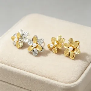 Detailansicht von zwei Paar 18K vergoldeten Blumenohrringen mit Perlen auf einer Box