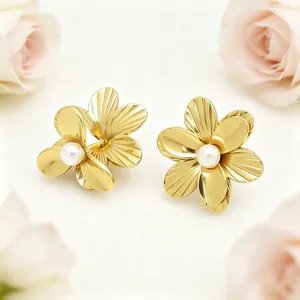 Makroansicht eleganter, doppellagiger goldener Blumenohrringe mit Perlenakzenten.