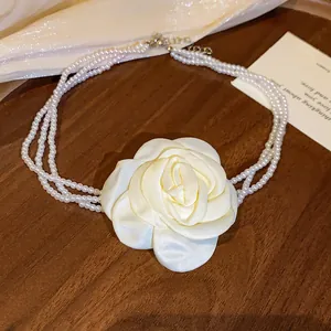 Detailansicht eines vintage cremefarbenen Stoffrosen- und dreireihigen Perlenchokers.