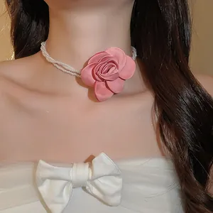 Nahaufnahme eines eleganten Perlen-Chokers mit einer großen rosa Stoffrose