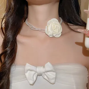 Detaillierte Ansicht eines Vintage-Perlenchokers mit weißer Rose, am Hals getragen