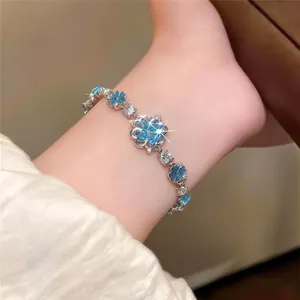 Detailed view of an elegant silver bracelet featuring sparkling blue zircon flower pendants