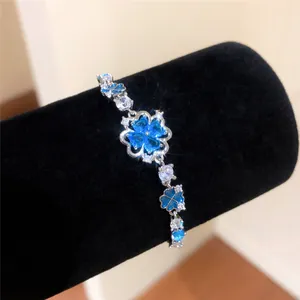 Silver bracelet with blue clover zircon flowers on black display stand