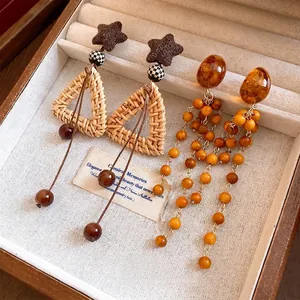 Boucles d'oreilles rétro en résine avec perles et glands dans un élégant coffret à bijoux