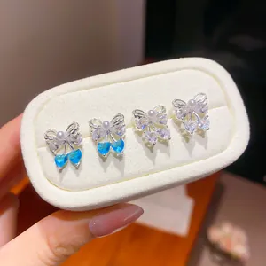 Exquisite detail of bow-knot zircon stud earrings with blue and clear heart gems