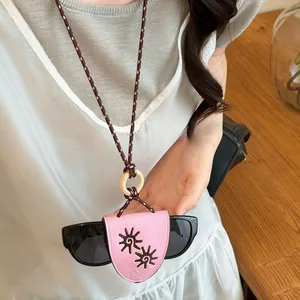 Detailed view of pink leather sunglasses holder necklace with sun embroidery