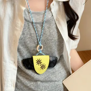 Detail of yellow leather glasses clip necklace with blue braided rope