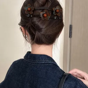 Detailopname van een haarclip met acrylblloemen in een knotje