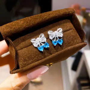 Exquisite silver bow stud earrings featuring white zircon and blue heart-shaped drops