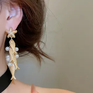 Elegant vintage gold starfish and dangling fish drop earrings with white pearls detail