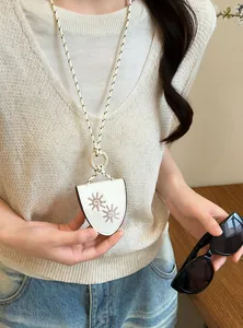 Close-up of white leather pendant necklace with sun embroidery used as a glasses holder