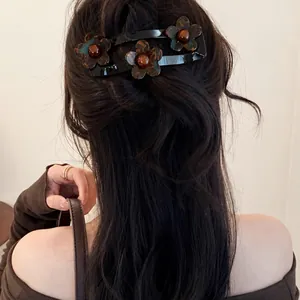 Achteraanzicht van een vrouw met een chique schildpad acryl bloem haarspeld in haar haar