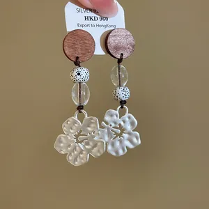Retro silver earrings with wooden studs and textured floral pendants