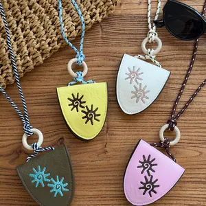 Detailed view of four colorful leather eyeglass holder necklaces with sun embroidery
