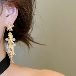 Detailed view of vintage ocean-style earrings with starfish, fish, and pearl charms. Elegant gift.
