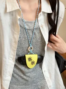 Lifestyle shot of a leather glasses holder necklace with sun patterns on a model