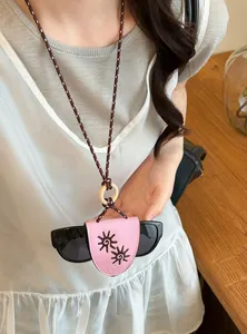 Detailed view of pink leather sunglasses holder necklace with braided cord and sun pattern