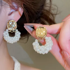 Nahaufnahme von französischen Vintage-Ohrringen mit Goldmetall und Perlenringen.