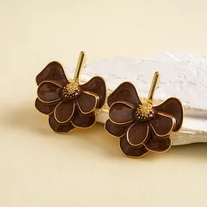 Close-up detail of vintage brown enamel flower earrings with gold-toned metal accents