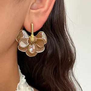 Close-up detail of vintage gold-tone flower stud earrings with brown enamel petals