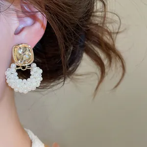 Elegante Detailansicht von französischen Vintage-Perlenohrringen mit Goldakzenten am Ohr.