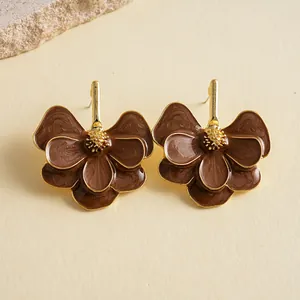 Close-up of vintage brown enamel flower stud earrings with gold metal accents