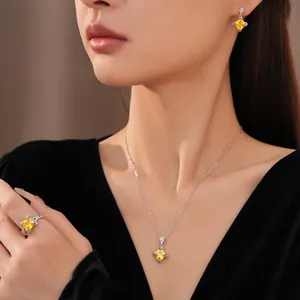 Nahaufnahme eines eleganten Schmucksets aus gelbem Zirkon-Rhombus an einem weiblichen Model