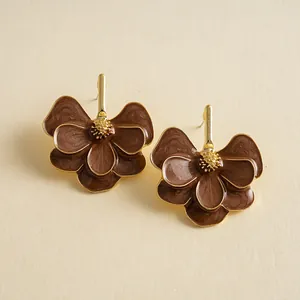 Detailed close-up shot of vintage brown enamel flower petal earrings with golden center