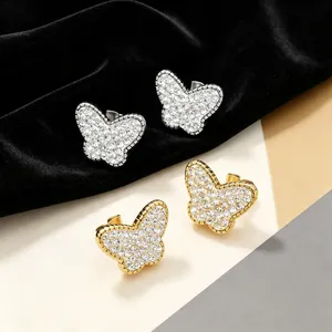 Gros plan de boucles d'oreilles papillon serties de cristaux en or et argent