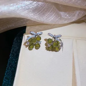 Elegant silver bow stud earrings with sparkling green grape-shaped zircon crystals