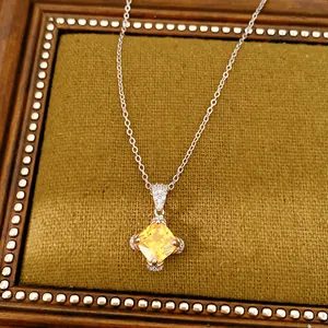 Nahaufnahme einer eleganten Halskette mit gelbem Zirkonia-Anhänger auf feinem Samt