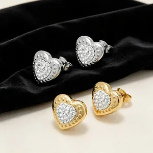 Détail de boucles d'oreilles en forme de cœur en acier titane avec cristaux pavés