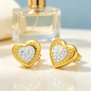 Gros plan de boucles d'oreilles cœur en or avec strass scintillants sertis en pavé.