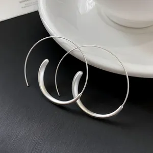 Detailed macro view of minimalist silver large hoop earrings with unique geometric design