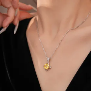 Nahaufnahme einer eleganten Silberkette mit einem funkelnden gelben Zirkon-Anhänger