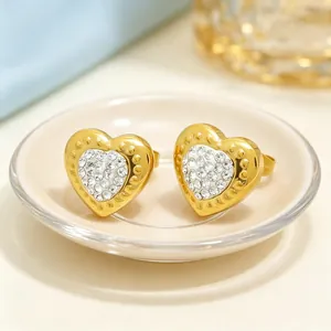 Vue détaillée de boucles d'oreilles en forme de cœur dorées avec pavé de strass