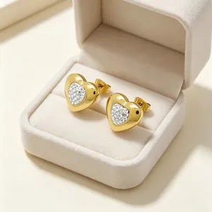 Gros plan de boucles d'oreilles cœur en or serties de strass étincelants en boîte