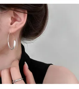 Close-up showing the elegant wearing effect of minimalist silver hoop earrings on a model