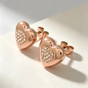Vue rapprochée d'élégantes boucles d'oreilles cœur en or rose avec cristaux scintillants