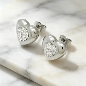 Gros plan de boucles d'oreilles cœur en acier titane avec incrustation de cristaux clairs