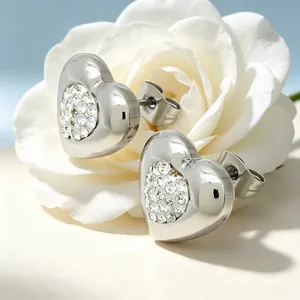 Détail des boucles d'oreilles en forme de cœur argenté avec cristaux brillants