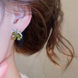 Gedetailleerd overzicht van elegante strikoorbellen met groene kristallen op het oor