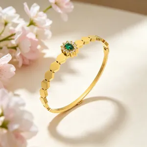 Vue detaillee d'un bracelet jonc vintage dore avec un motif de tournesol et pierre verte