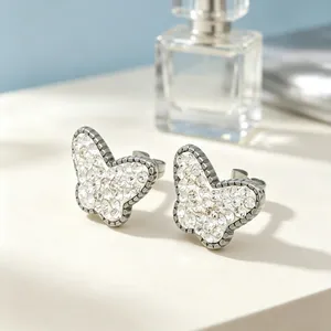Gros plan de boucles d'oreilles papillon avec strass étincelants en acier titane résistant