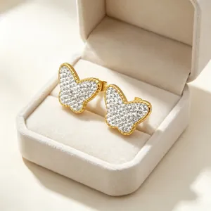 Vue détaillée de boucles d'oreilles papillon étincelantes en strass dans une boîte