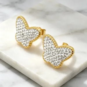 Gros plan détaillé de boucles d'oreilles papillon en acier titane serties de cristaux.