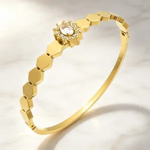 Vue détaillée d'un bracelet jonc vintage en or avec maillons hexagonaux et cristal