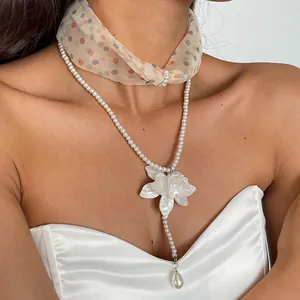 Close-up of white resin flower and pearl double-layer necklace on model