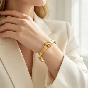Gros plan d'un bracelet tournesol doré avec cristal rose sur le poignet d'un mannequin.